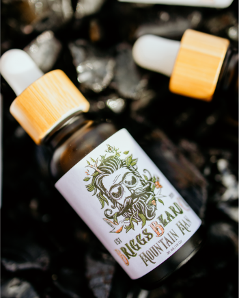 Mountain man beard oil lying in black stones